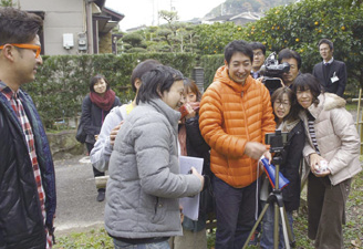 撮影風景、写真中央付近のオレンジの服が志場さん。