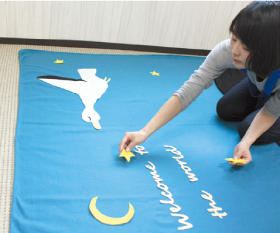 3.鈴木さんがフェルトを切って手作りしたコウノトリ、星や月などの飾りを配置。