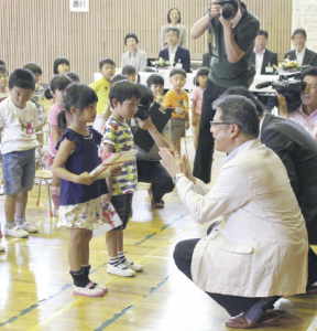 代表の園児2人が絵本を受け取る様子