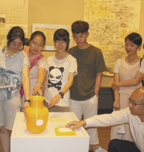 陶器のレプリカに触れる中国の学生や教員