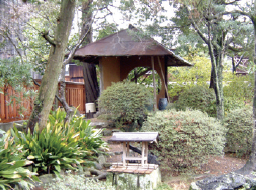 重厚なレンガ作りの高い塀に囲まれた日本庭園。しだれ柳や紅葉、ツバキなど、四季を通じて楽しめます