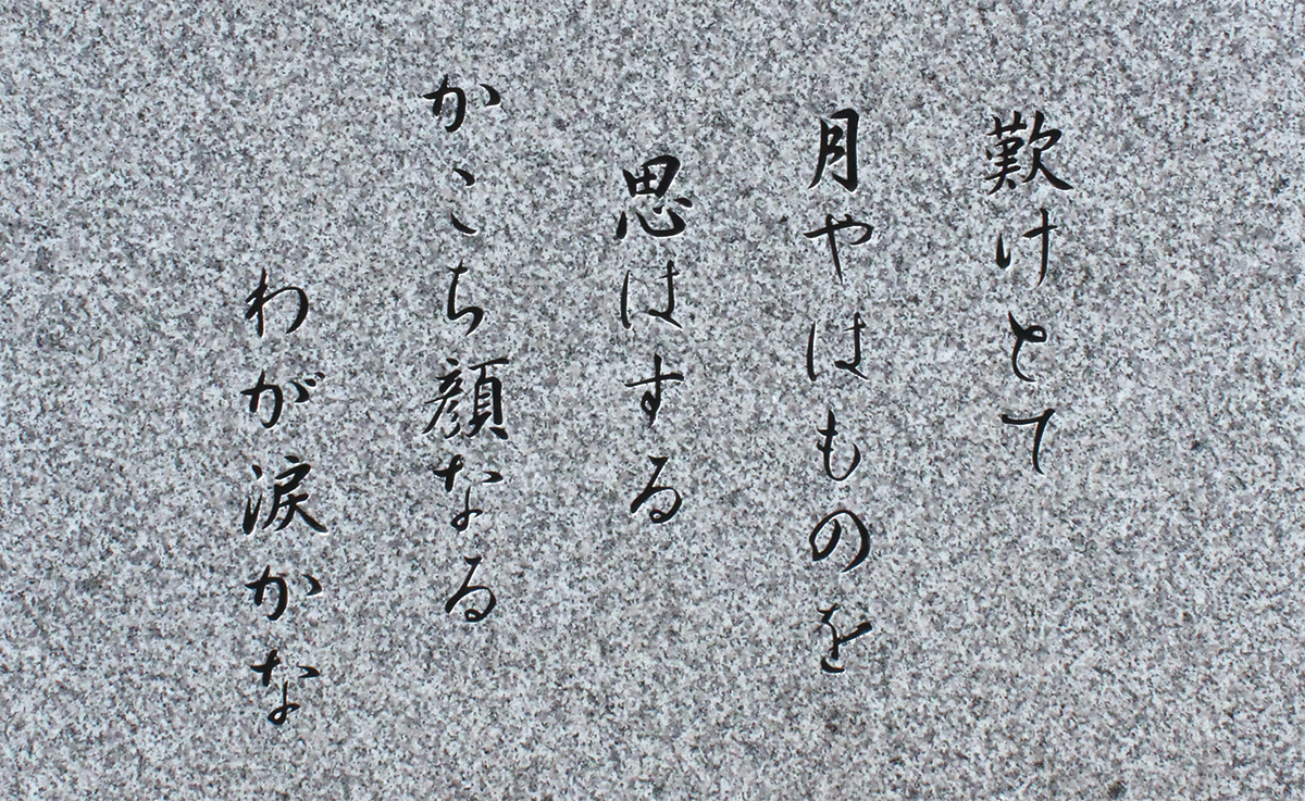 像の足元の石碑に刻まれた、西行の恋の歌