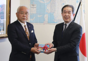 西田代表理事(左)から交通安全手帳を受け取る阿形教育長