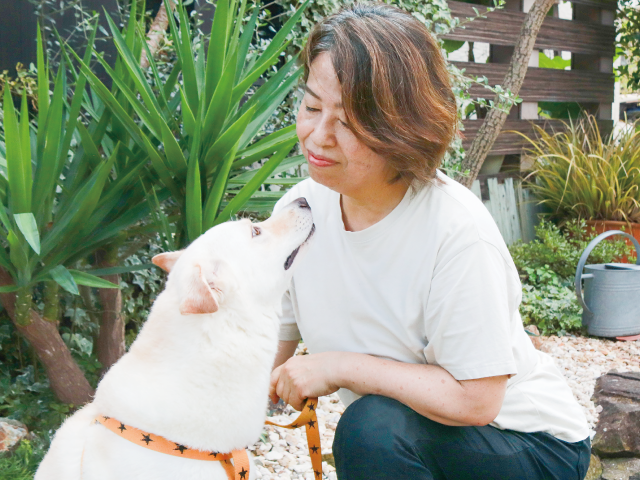「モチちゃん」と声をかける生賀さんを見つめ、甘える保護犬のモチ