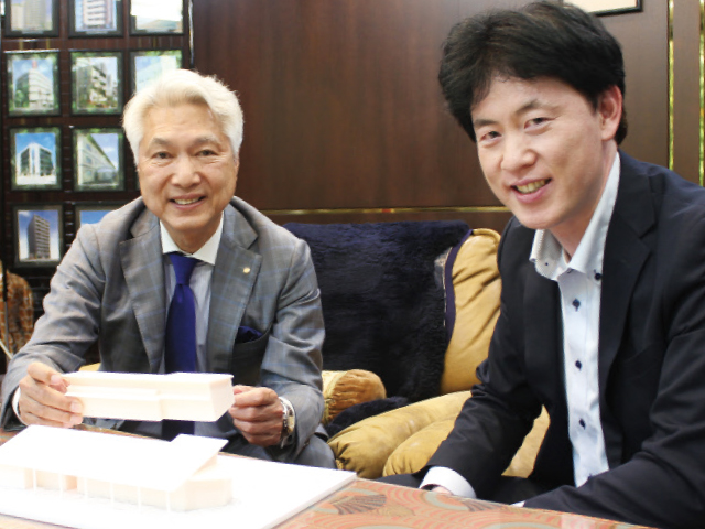 模型を手に話す樫畑社長と(左)、同社開発室長の山畑年広さん